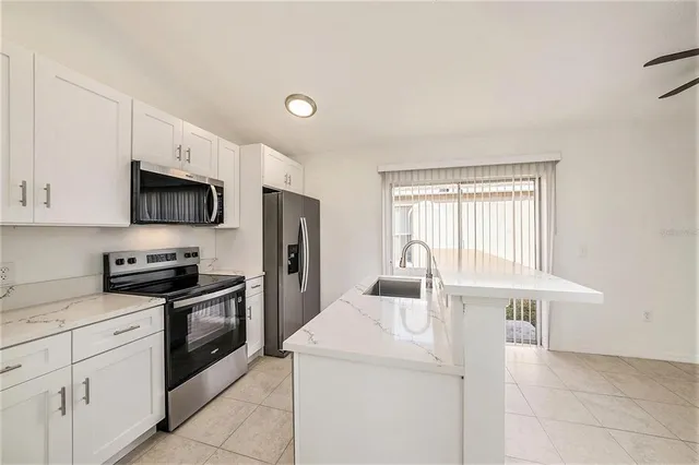a kitchen with stainless steel appliances granite countertop a stove a sink and a refrigerator