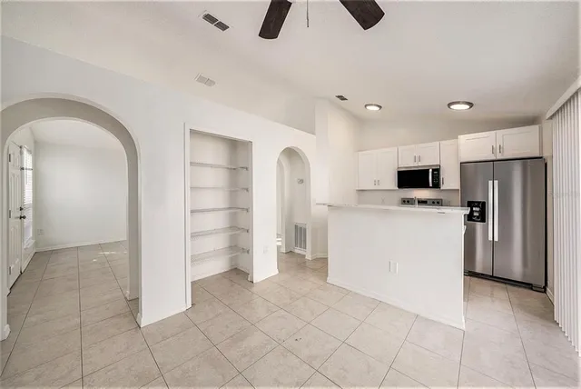 a view of kitchen with cabinets and refrigerator