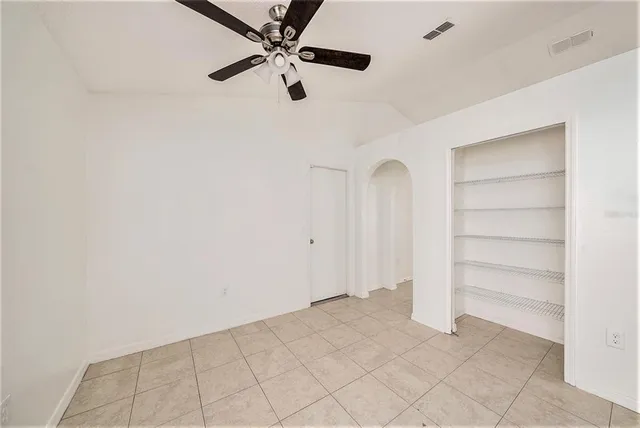 an empty room with closet and windows