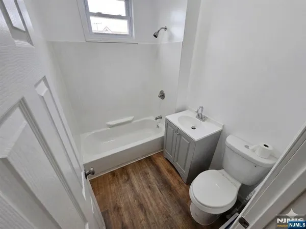 a toilet sitting next to a white sink and vanity