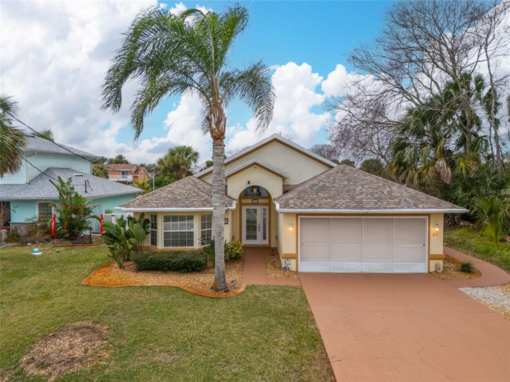 a front view of a house with a garden and trees