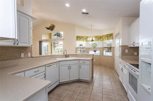 a kitchen with granite countertop white cabinets and white appliances