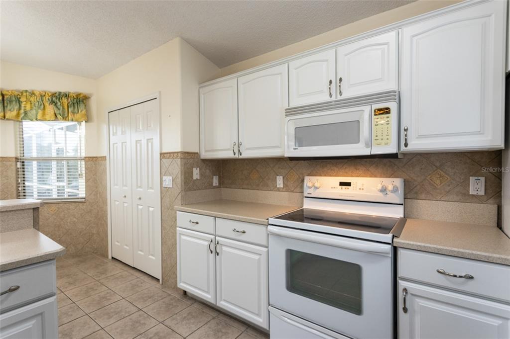 21 Comanche Court Palm Coast, FL 32137 - Photo 13 of 50 a kitchen with granite countertop white cabinets and white appliances