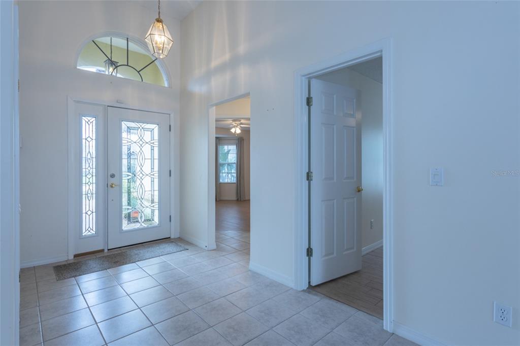 21 Comanche Court Palm Coast, FL 32137 - Photo 8 of 50 a view of a hallway with a chandelier fan and glass door