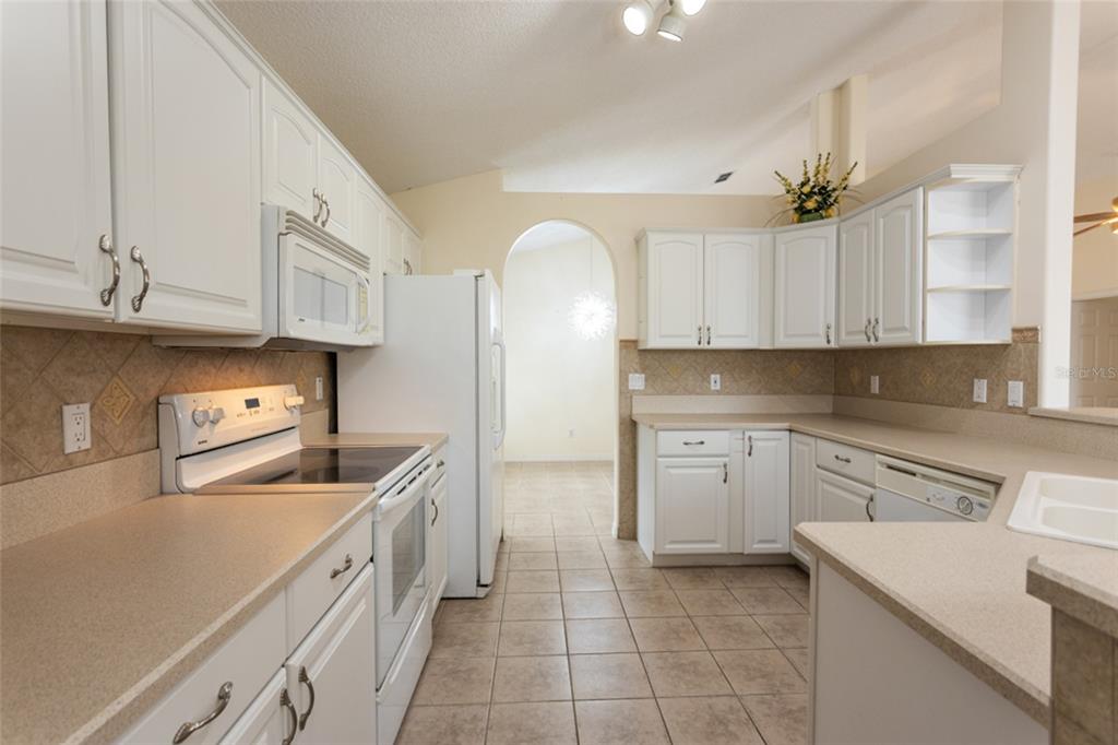 21 Comanche Court Palm Coast, FL 32137 - Photo 10 of 50 a kitchen with stainless steel appliances granite countertop a sink a stove and cabinets