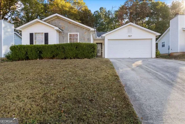 a view of a house with a yard and garage