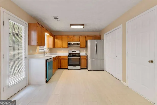 a kitchen with stainless steel appliances granite countertop a stove a sink and a refrigerator