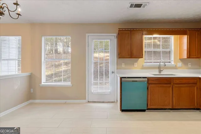 an empty room with a window and a kitchen view