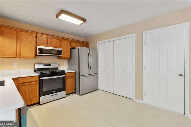 a kitchen with stainless steel appliances granite countertop a refrigerator stove and microwave