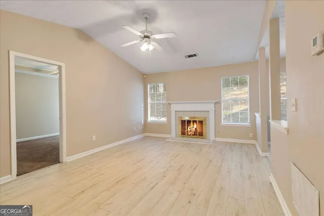 a view of an empty room with a fireplace and a window