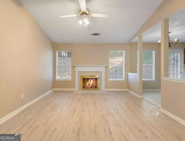 wooden floor fireplace and windows in an empty room