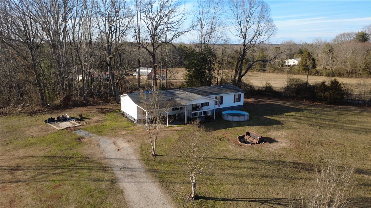 145 Finley Road Belton, SC 29627 - Photo 7 of 9 This expansive rural property offers a home with a welcoming porch and abundant outdoor space.
