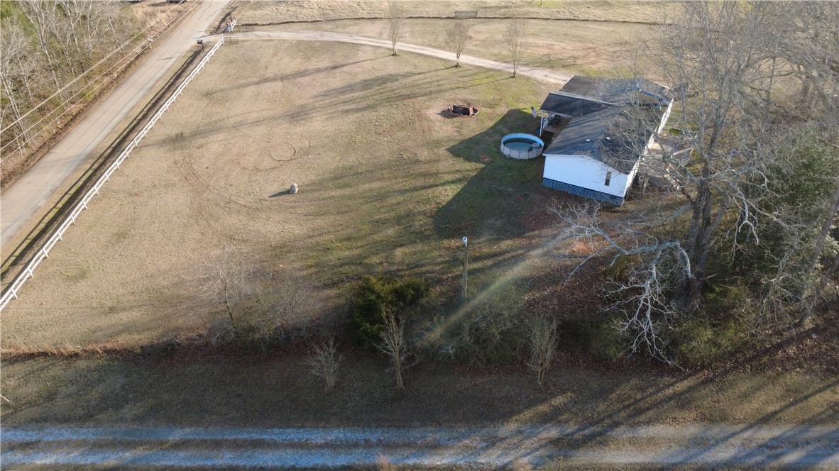 145 Finley Road Belton, SC 29627 - Photo 8 of 9 Expansive property featuring a charming home, inviting pool, and a fire pit area.
