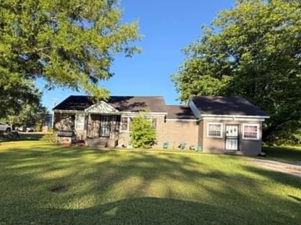 a view of a house with a big yard and large trees