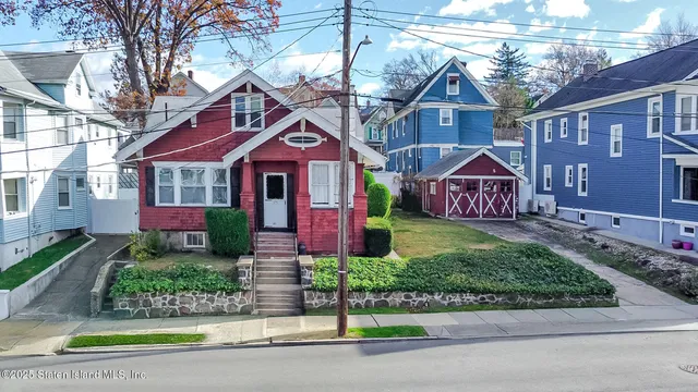 a front view of a house with a garden and plants