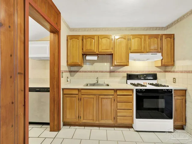 a kitchen with a stove a sink and a refrigerator