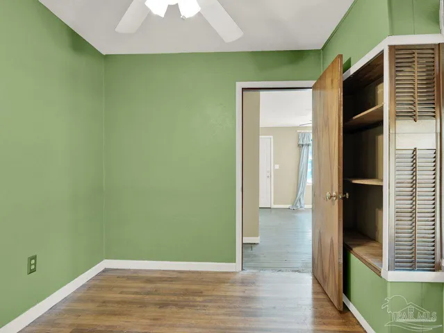 a view of a room that has wooden floor and a window
