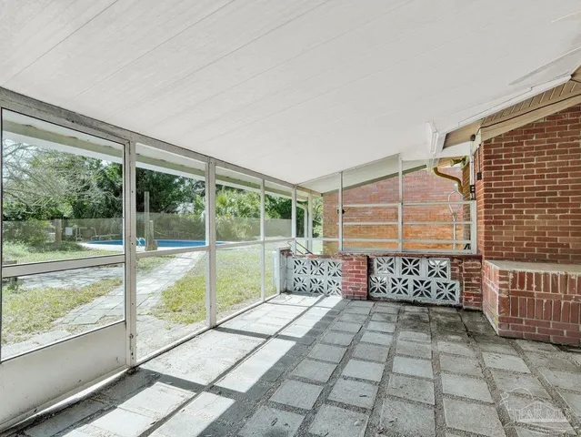 a view of a porch with a floor to ceiling window next to a yard
