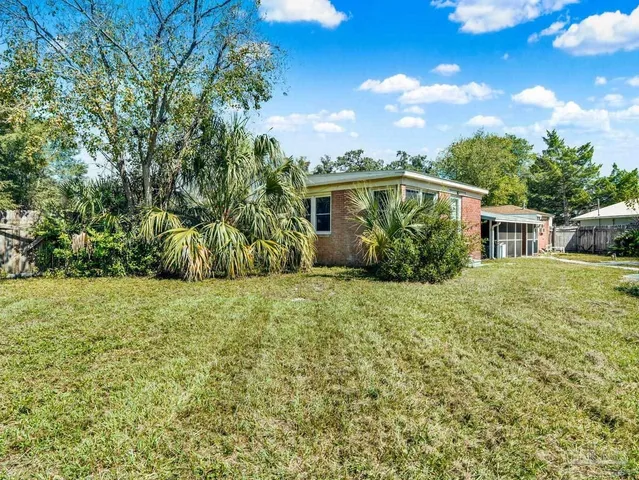 a front view of house with yard and trees around