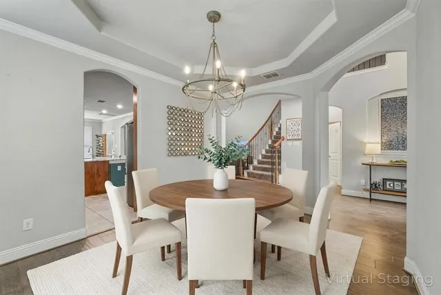 a dining room with furniture a chandelier and wooden floor