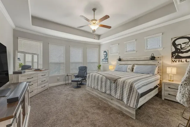 a spacious bedroom with a bed a couch and a ceiling fan
