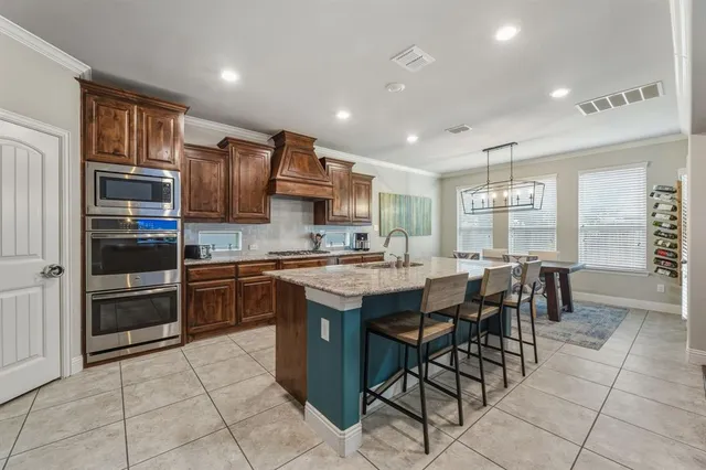 a kitchen with stainless steel appliances granite countertop a stove top oven a sink a counter top space and cabinets