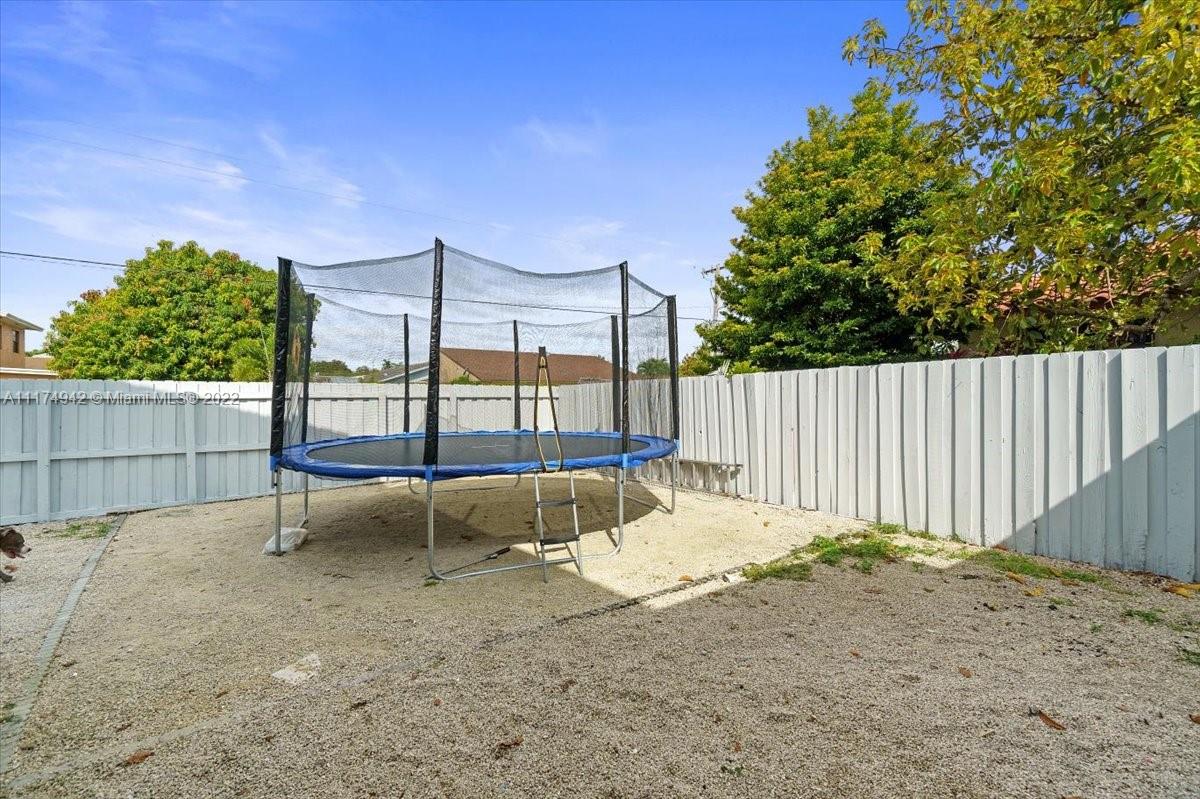 10975 Southwest 38th Terrace Miami, FL 33165 - Photo 19 of 21 a view of a backyard with a bench and wooden fence