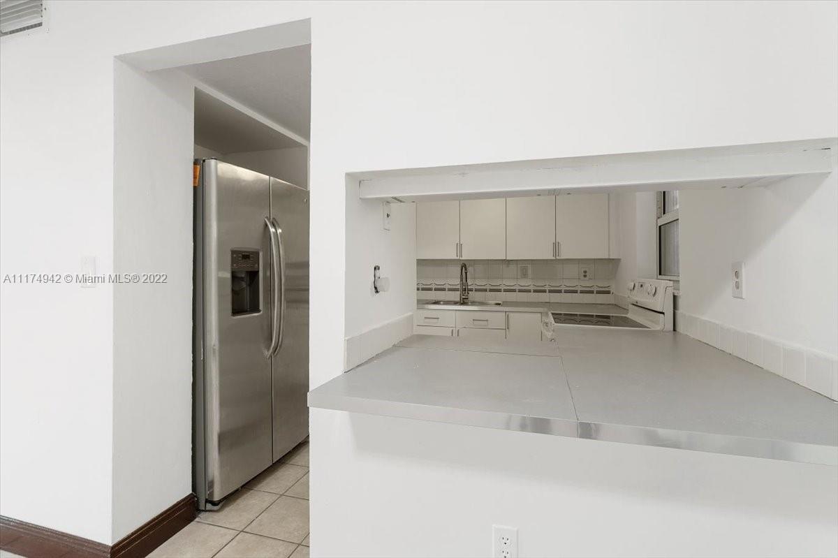 10975 Southwest 38th Terrace Miami, FL 33165 - Photo 6 of 21 a view of a kitchen with refrigerator and window