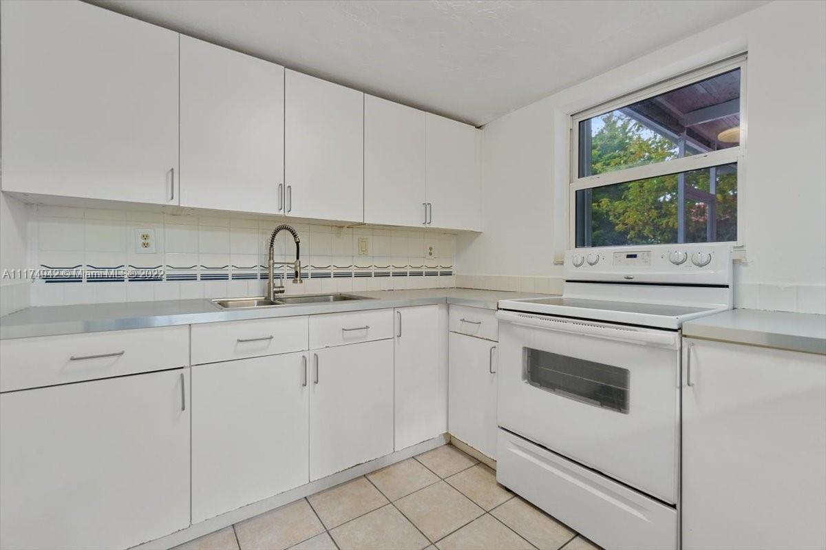 10975 Southwest 38th Terrace Miami, FL 33165 - Photo 7 of 21 a kitchen with granite countertop white cabinets stainless steel appliances and a sink