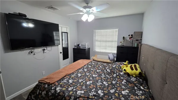 a bedroom with bed and flat tv screen