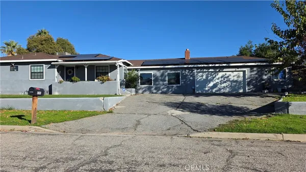 a front view of a house with a yard and potted plants