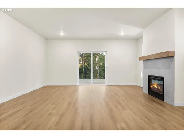a view of an empty room with a fireplace and a window