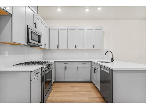 a kitchen with stainless steel appliances granite countertop a sink stove and microwave