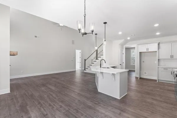 a large white kitchen with a window wooden floor and stainless steel appliances