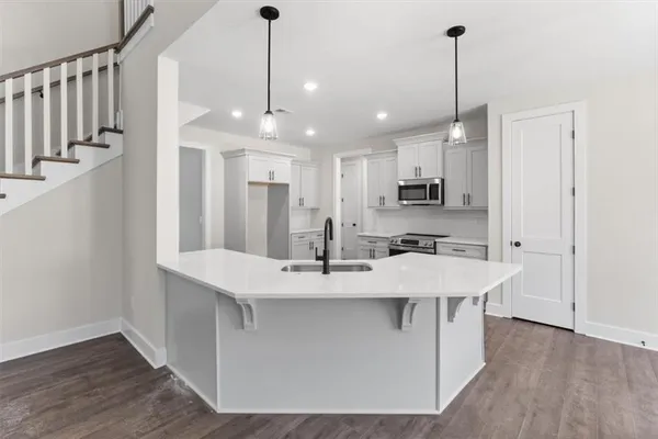 a kitchen with stainless steel appliances a stove a sink and white cabinets next to a window