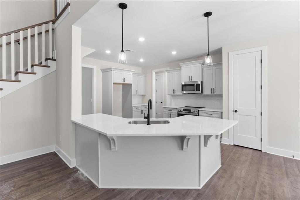 14 Everwood Court Rome, GA 30161 - Photo 22 of 54 a kitchen with stainless steel appliances kitchen island granite countertop a sink a refrigerator and a wooden floor