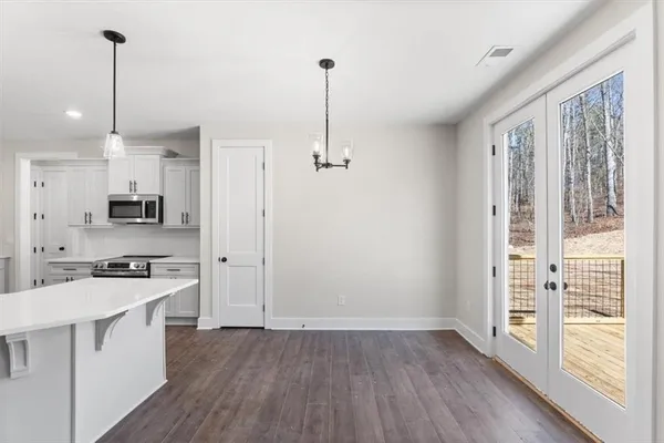 a view of kitchen with stainless steel appliances sink refrigerator and wooden floor