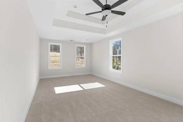 an empty room with windows and fan