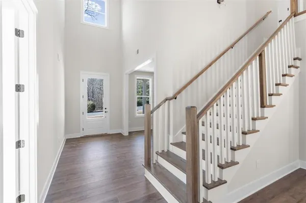 a view of staircase with wooden floor and white walls