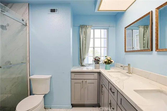a bathroom with a granite countertop toilet sink and mirror