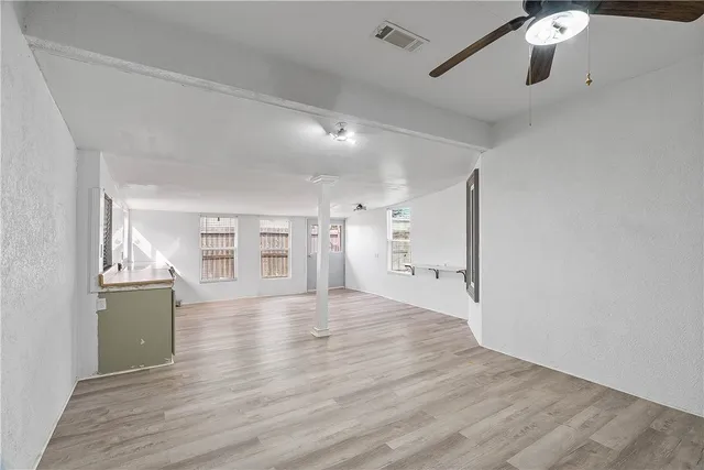 a view of empty room with wooden floor