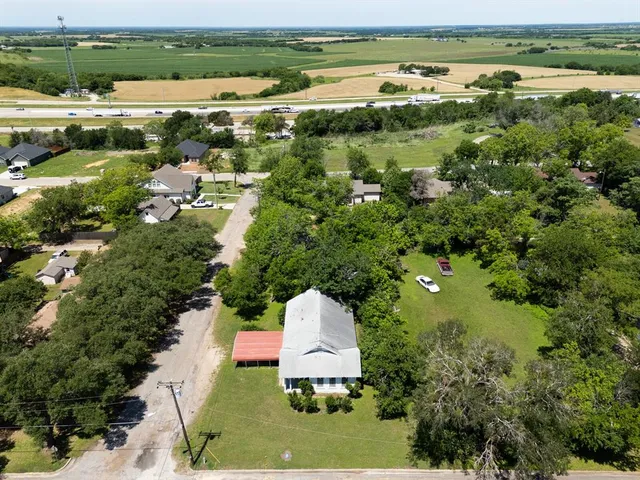 an aerial view of a house with a garden and lake view