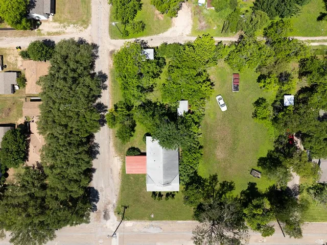 an aerial view of a house with a yard and lake view