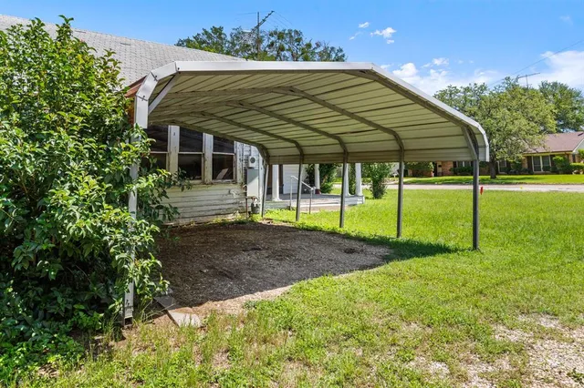 a view of a house with backyard and trees