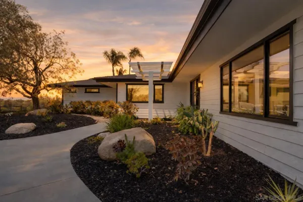 a view of a house with backyard and sitting area