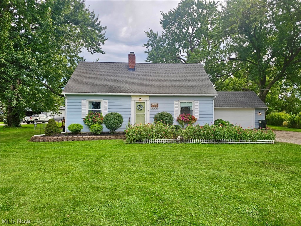 6620 West Lake Road Vermilion, OH 44089 - Photo 1 of 34 Light blue siding exterior with white window shutters, a dark shingle roof, and a red brick chimney