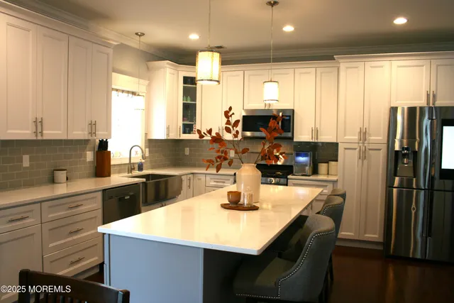 a kitchen with stainless steel appliances granite countertop a sink refrigerator and cabinets