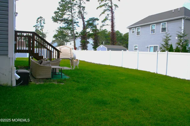 a view of house with backyard and a slide