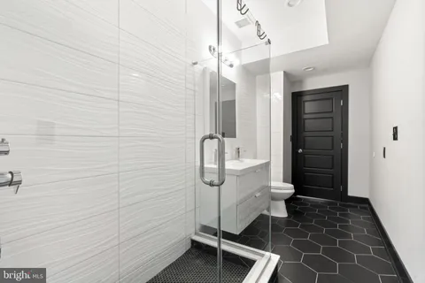 a bathroom with a sink a toilet and shower