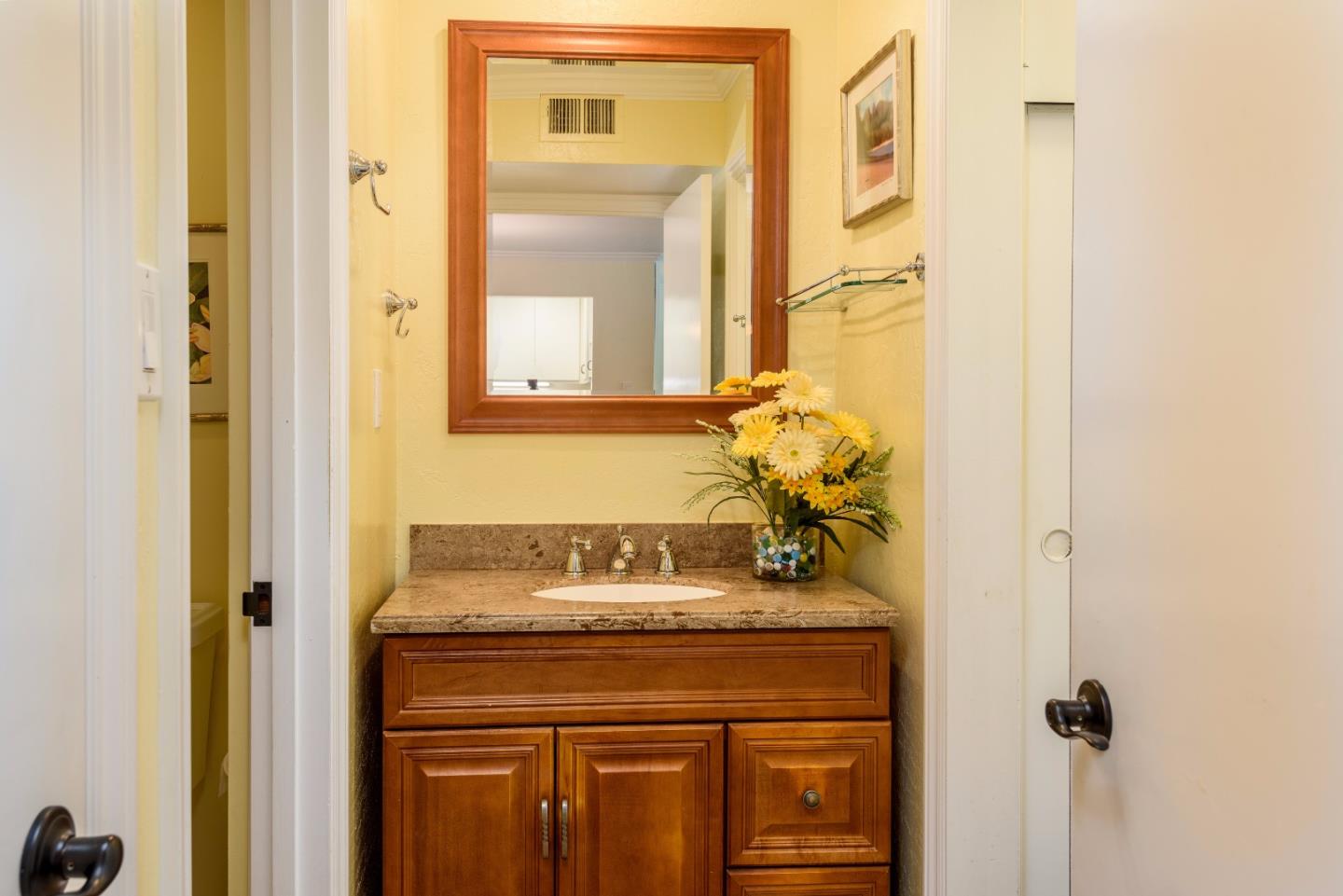 200 Elm Street, Unit 107 San Mateo, CA 94401 - Photo 9 of 11 a bathroom with a granite countertop sink a mirror and a shower